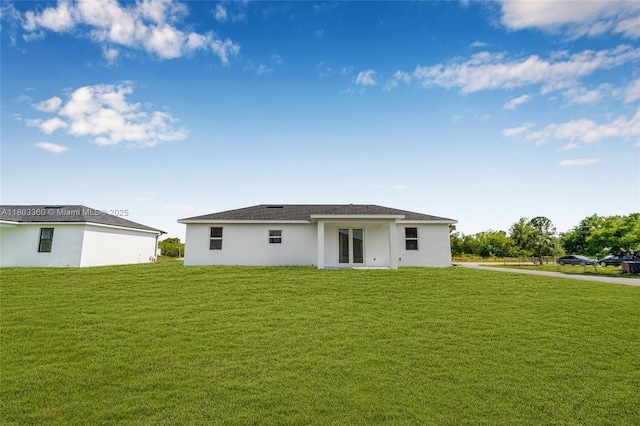 2506 5th St SW, Lehigh Acres, FL 33976 - back of property with a lawn and stucco siding
