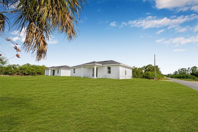 2506 5th St SW, Lehigh Acres, FL 33976 - view of side of home with a lawn and stucco siding