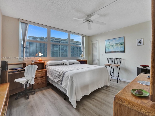 3113 S Ocean Dr Unit 603, Hallandale Beach, FL 33009 - bedroom with light wood-style floors, a textured ceiling, a desk, a closet, and ceiling fan