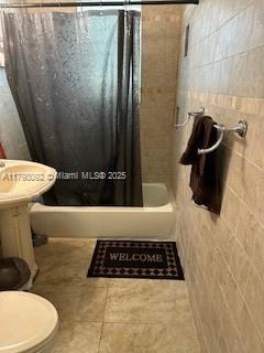 446 NW 80th St, Miami, FL 33150 - full bathroom featuring shower / tub combo, tile walls, toilet, and tile patterned floors