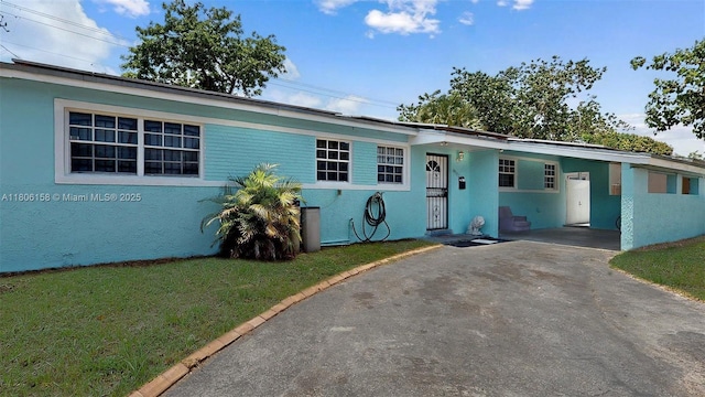 18502 NW 23rd Ct, Miami Gardens, FL 33056 - view of front of house with asphalt driveway, a carport, and a front lawn