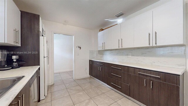 18502 NW 23rd Ct, Miami Gardens, FL 33056 - kitchen with white cabinetry, dark brown cabinets, decorative backsplash, and light countertops