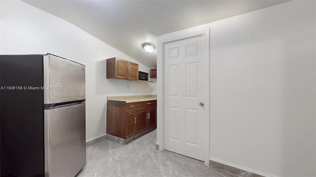 18502 NW 23rd Ct, Miami Gardens, FL 33056 - kitchen featuring freestanding refrigerator, light countertops, lofted ceiling, and light marble finish floors