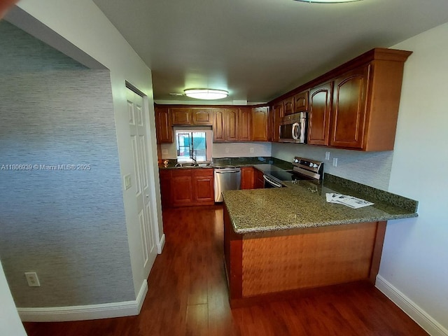 20033 NE 2nd Pl, Miami, FL 33179 - kitchen featuring appliances with stainless steel finishes, dark wood-style flooring, a peninsula, a sink, and baseboards