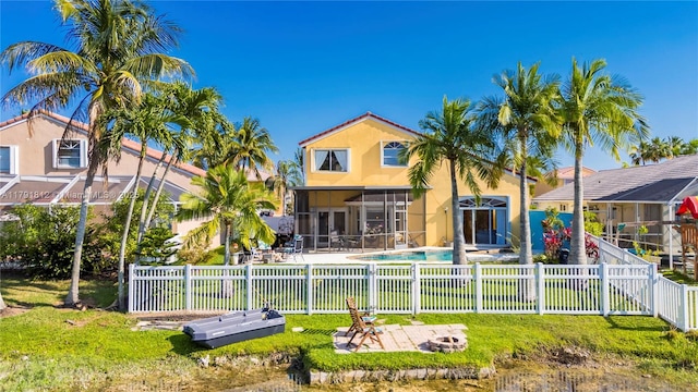 1060 NW 192nd Ave, Pembroke Pines, FL 33029 - back of property featuring stucco siding, a patio area, a fenced backyard, a sunroom, and an outdoor fire pit