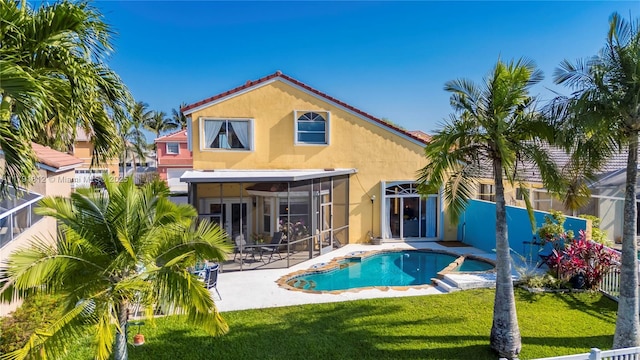 1060 NW 192nd Ave, Pembroke Pines, FL 33029 - rear view of property with stucco siding, a sunroom, a patio area, a lawn, and a tiled roof