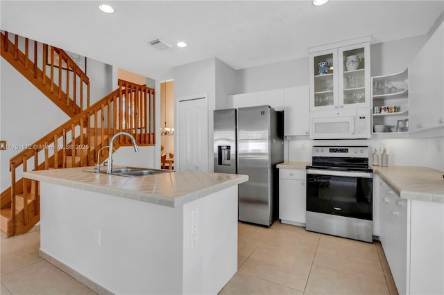 1060 NW 192nd Ave, Pembroke Pines, FL 33029 - kitchen featuring stainless steel appliances, a sink, white cabinetry, a center island with sink, and glass insert cabinets