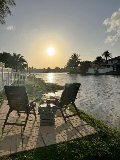 1060 NW 192nd Ave, Pembroke Pines, FL 33029 - patio terrace at dusk featuring a water view and a patio
