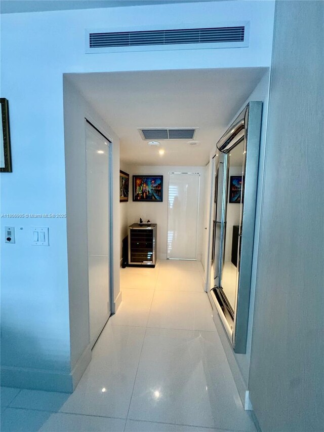 9801 Collins Ave Unit 19J, Bal Harbour, FL 33154 - hall featuring light tile patterned floors, beverage cooler, and baseboards