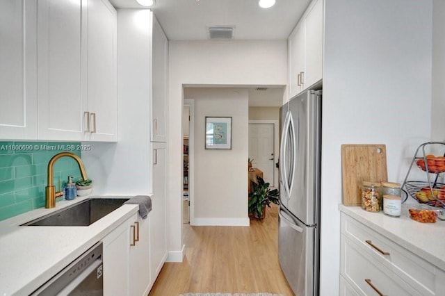 1222 S 14th Ct S, Lake Worth, FL 33460 - kitchen featuring appliances with stainless steel finishes, a sink, white cabinetry, and light wood-style flooring