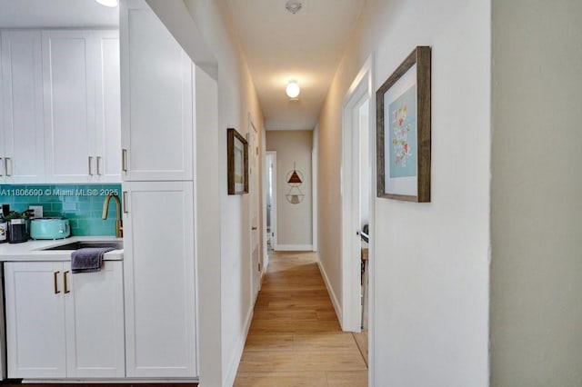 1222 S 14th Ct S, Lake Worth, FL 33460 - corridor with a sink, light wood finished floors, and baseboards