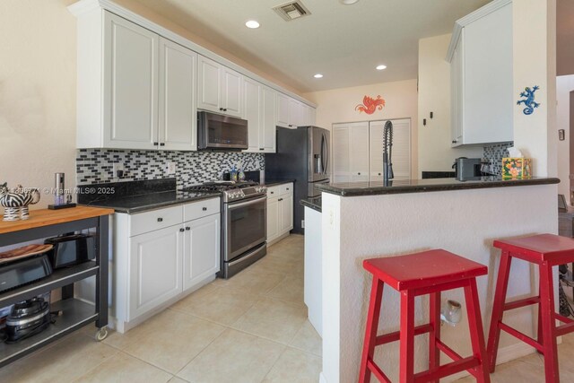 19311 SW 61st St, Pembroke Pines, FL 33332 - kitchen featuring appliances with stainless steel finishes, tasteful backsplash, dark countertops, white cabinets, and recessed lighting