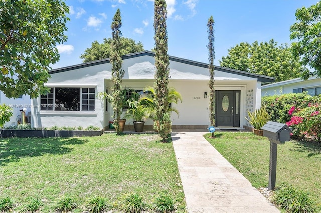 1693 NE 171st St, North Miami Beach, FL 33162 - view of front of property featuring a front yard and stucco siding
