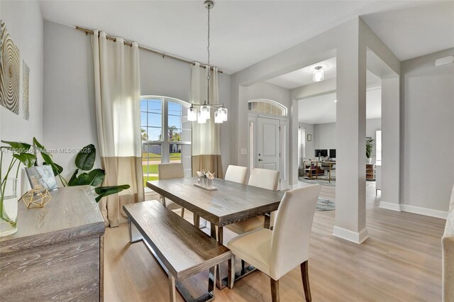 2316 SW Santana Ave, Port St Lucie, FL 34953 - dining space featuring light wood-type flooring, a chandelier, and baseboards