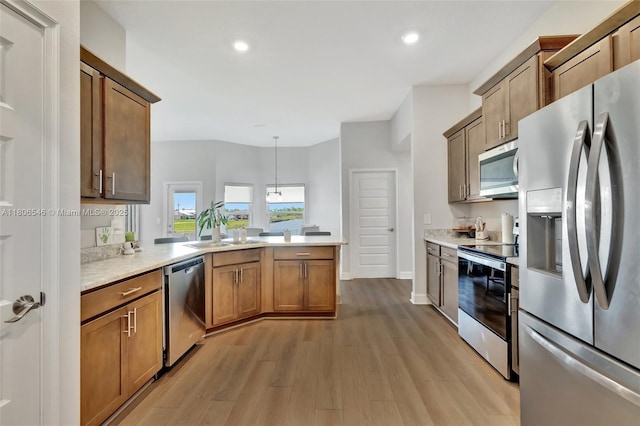 2316 SW Santana Ave, Port St Lucie, FL 34953 - kitchen featuring appliances with stainless steel finishes, a peninsula, light wood-type flooring, light countertops, and a sink