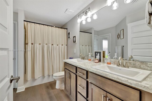 2316 SW Santana Ave, Port St Lucie, FL 34953 - bathroom featuring wood finished floors, toilet, double vanity, and shower / tub combo