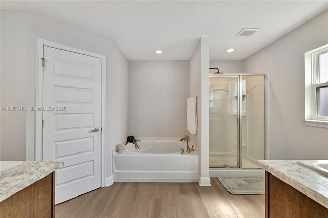 2316 SW Santana Ave, Port St Lucie, FL 34953 - bathroom featuring wood finished floors, vanity, a stall shower, a bath, and recessed lighting