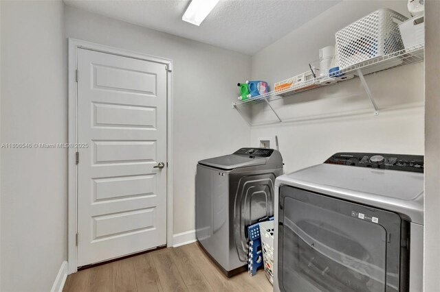 2316 SW Santana Ave, Port St Lucie, FL 34953 - laundry room featuring independent washer and dryer, light wood-style flooring, and baseboards