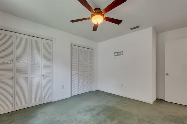 9620 E Calusa Club Dr, Miami, FL 33186 - unfurnished bedroom featuring two closets, carpet floors, baseboards, and a ceiling fan