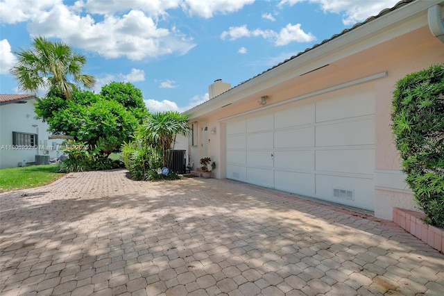 9620 E Calusa Club Dr, Miami, FL 33186 - garage featuring central AC unit and decorative driveway