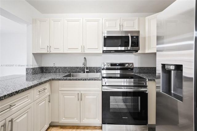 4609 SW 143rd Pl, Miami, FL 33175 - kitchen with appliances with stainless steel finishes, a sink, white cabinets, dark stone counters, and light tile patterned flooring