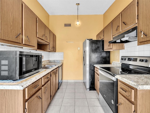 3034 NW 204th Ter, Miami Gardens, FL 33056 - kitchen featuring stainless steel appliances, under cabinet range hood, decorative backsplash, light countertops, and a sink