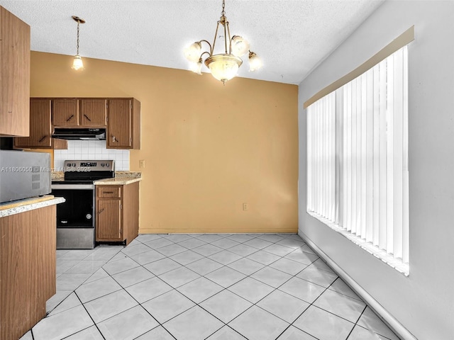 3034 NW 204th Ter, Miami Gardens, FL 33056 - kitchen with stainless steel range with electric stovetop, under cabinet range hood, light countertops, decorative backsplash, and brown cabinets