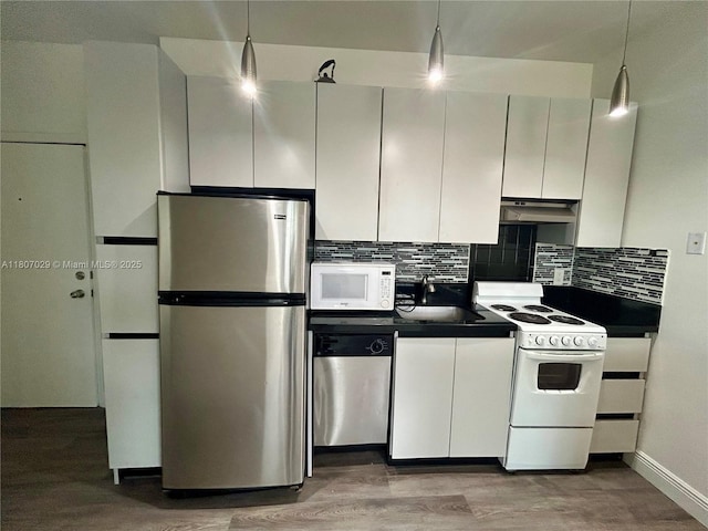 1244 Pennsylvania Ave Unit 305, Miami Beach, FL 33139 - kitchen with stainless steel appliances, dark countertops, a sink, tasteful backsplash, and light wood-type flooring