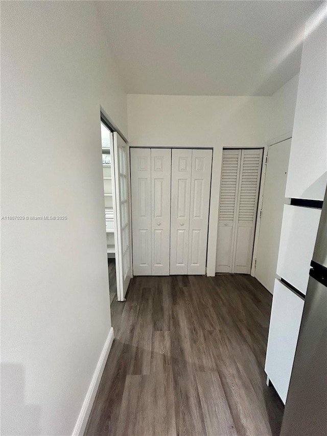 1244 Pennsylvania Ave Unit 305, Miami Beach, FL 33139 - unfurnished bedroom with dark wood-style floors, two closets, and baseboards