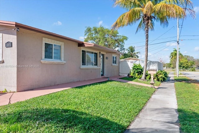 7601 Simms St, Hollywood, FL 33024 - view of front facade with stucco siding and a front yard