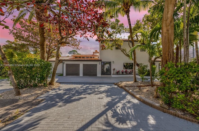 210 NE 107th St, Miami Shores, FL 33161 - mediterranean / spanish home featuring stucco siding, an attached garage, decorative driveway, and a tiled roof