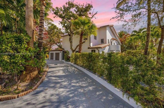 210 NE 107th St, Miami Shores, FL 33161 - mediterranean / spanish-style house with a tile roof, a garage, stucco siding, and driveway