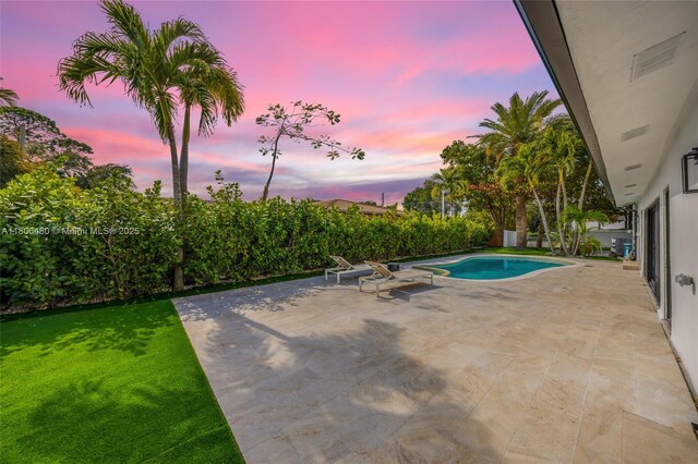 210 NE 107th St, Miami Shores, FL 33161 - pool at dusk featuring a patio area and a yard