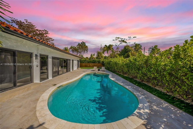 210 NE 107th St, Miami Shores, FL 33161 - pool at dusk featuring a patio area and a fenced backyard