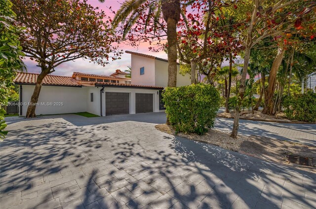 210 NE 107th St, Miami Shores, FL 33161 - view of front of house with an attached garage, driveway, central AC unit, and stucco siding