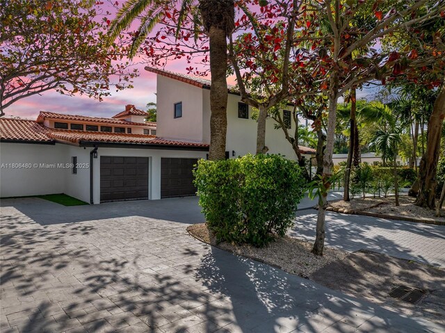 210 NE 107th St, Miami Shores, FL 33161 - mediterranean / spanish home with stucco siding, decorative driveway, a garage, and a tile roof