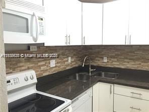 9320 Fontainebleau Blvd Unit 215, Miami, FL 33172 - kitchen with white appliances, white cabinetry, backsplash, and a sink