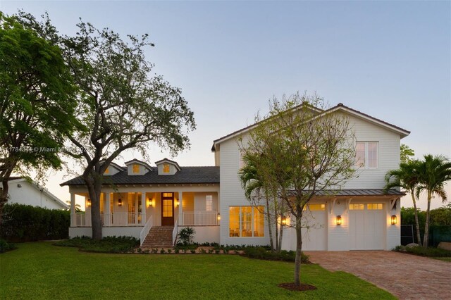 1051 San Pedro Ave, Coral Gables, FL 33156 - view of front of home featuring a porch, decorative driveway, a yard, an attached garage, and a standing seam roof