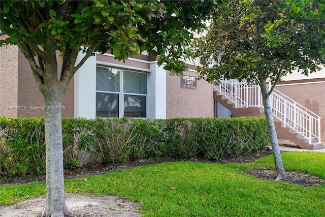 11201 SW 13th St Unit 101, Pembroke Pines, FL 33025 - view of home's exterior featuring stucco siding, stairs, and a lawn
