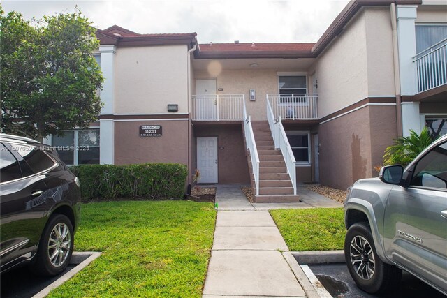 11201 SW 13th St Unit 101, Pembroke Pines, FL 33025 - view of building exterior featuring stairway and uncovered parking