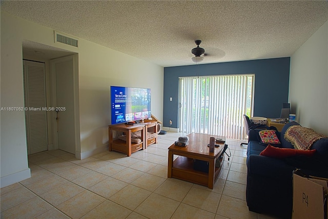 11201 SW 13th St Unit 101, Pembroke Pines, FL 33025 - living area featuring light tile patterned floors, a ceiling fan, baseboards, and a textured ceiling