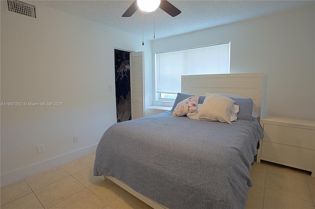 11201 SW 13th St Unit 101, Pembroke Pines, FL 33025 - bedroom featuring light tile patterned floors, a textured ceiling, a closet, ceiling fan, and baseboards