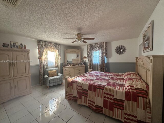 10075 NW 129th Ter, Hialeah Gardens, FL 33018 - bedroom with multiple windows, a textured ceiling, a ceiling fan, and light tile patterned flooring