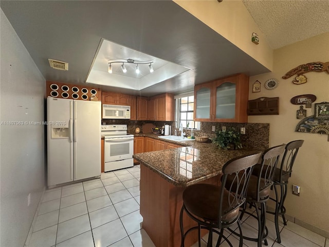 10075 NW 129th Ter, Hialeah Gardens, FL 33018 - kitchen featuring white appliances, a sink, a peninsula, glass insert cabinets, and decorative backsplash