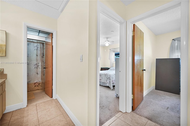 43 NW 109th Ct, Miami, FL 33172 - corridor featuring a textured ceiling, light tile patterned floors, baseboards, and light carpet