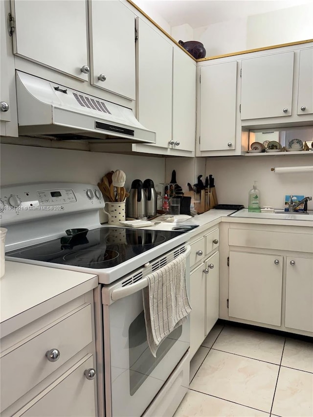 3850 Washington St Unit 1011, Hollywood, FL 33021 - kitchen featuring white range with electric cooktop, under cabinet range hood, light countertops, a sink, and light tile patterned floors