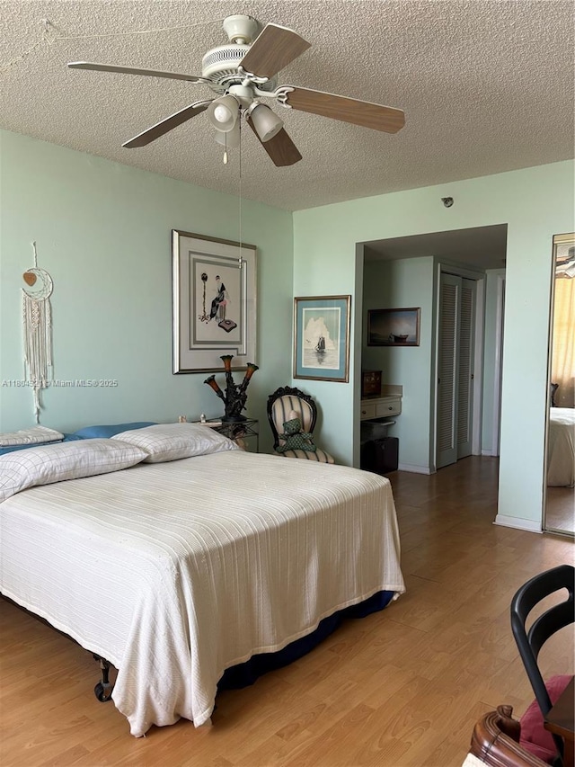 3850 Washington St Unit 1011, Hollywood, FL 33021 - bedroom featuring wood finished floors, a textured ceiling, and ceiling fan
