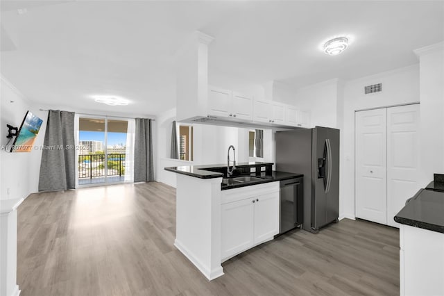 17150 N Bay Rd Unit 2814, Sunny Isles Beach, FL 33160 - kitchen featuring appliances with stainless steel finishes, dark countertops, light wood-style flooring, ornamental molding, and a peninsula