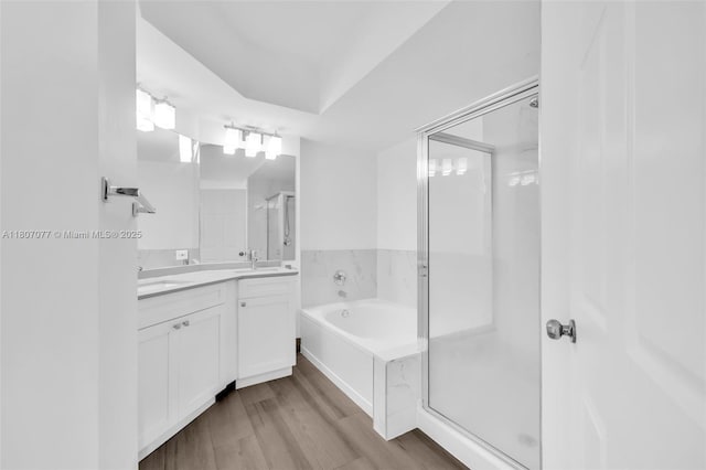 17150 N Bay Rd Unit 2814, Sunny Isles Beach, FL 33160 - full bathroom with double vanity, a stall shower, a garden tub, and wood finished floors