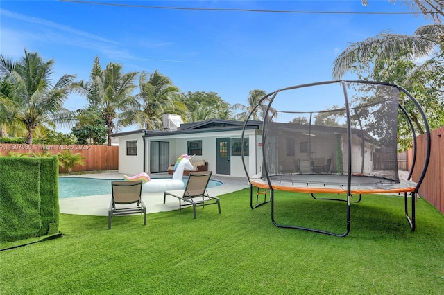 7531 Simms St, Hollywood, FL 33024 - back of house featuring a trampoline, a patio area, and stucco siding
